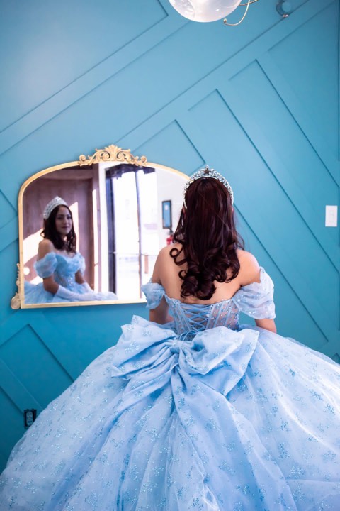 Quinceañera in blue gown, gold mirror back view at our Orem, Utah event venue