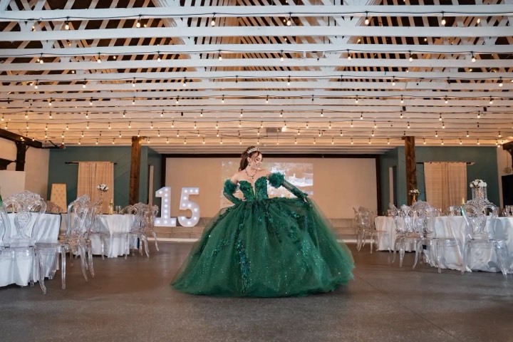 Quinceañera in emerald gown, marquee 15 and string lights at our Orem, Utah event venue
