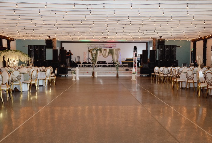 Full hall setup, stage, string lights, gold chairs at our Orem, Utah wedding and quinceañera venue