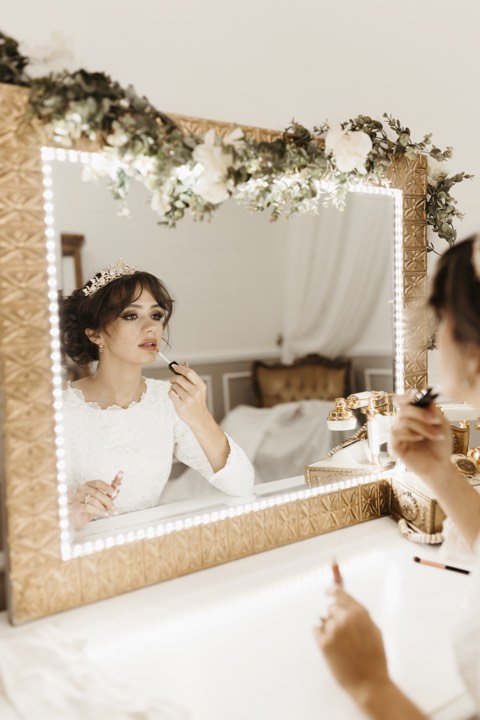 Bride at gold vanity mirror at our Orem, Utah wedding and quinceañera venue