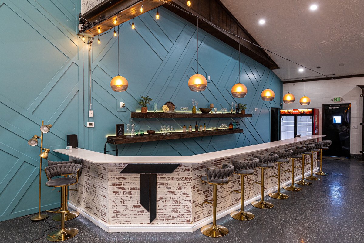 The bar under warm pendant lights against the blue accent wall at our Orem, Utah venue