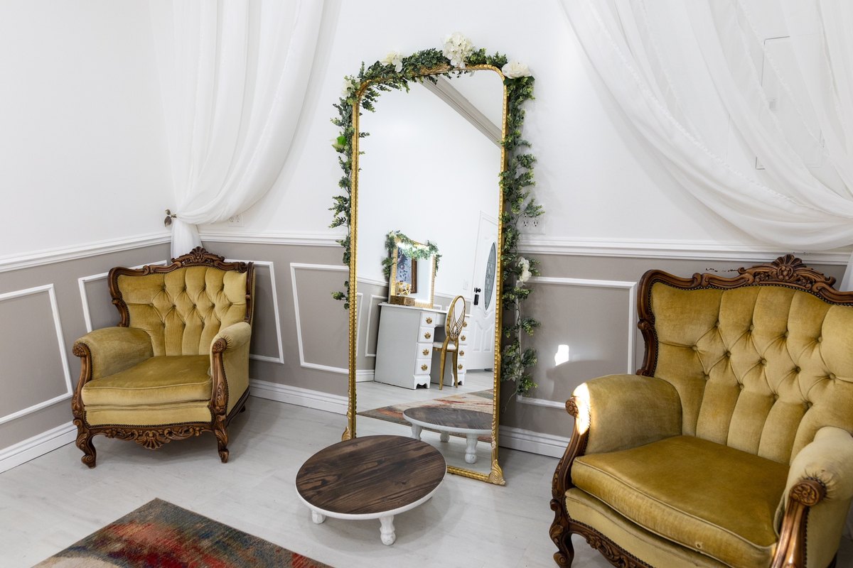 Gold velvet lounge chairs and a floral arch in the bridal suite at our Orem venue
