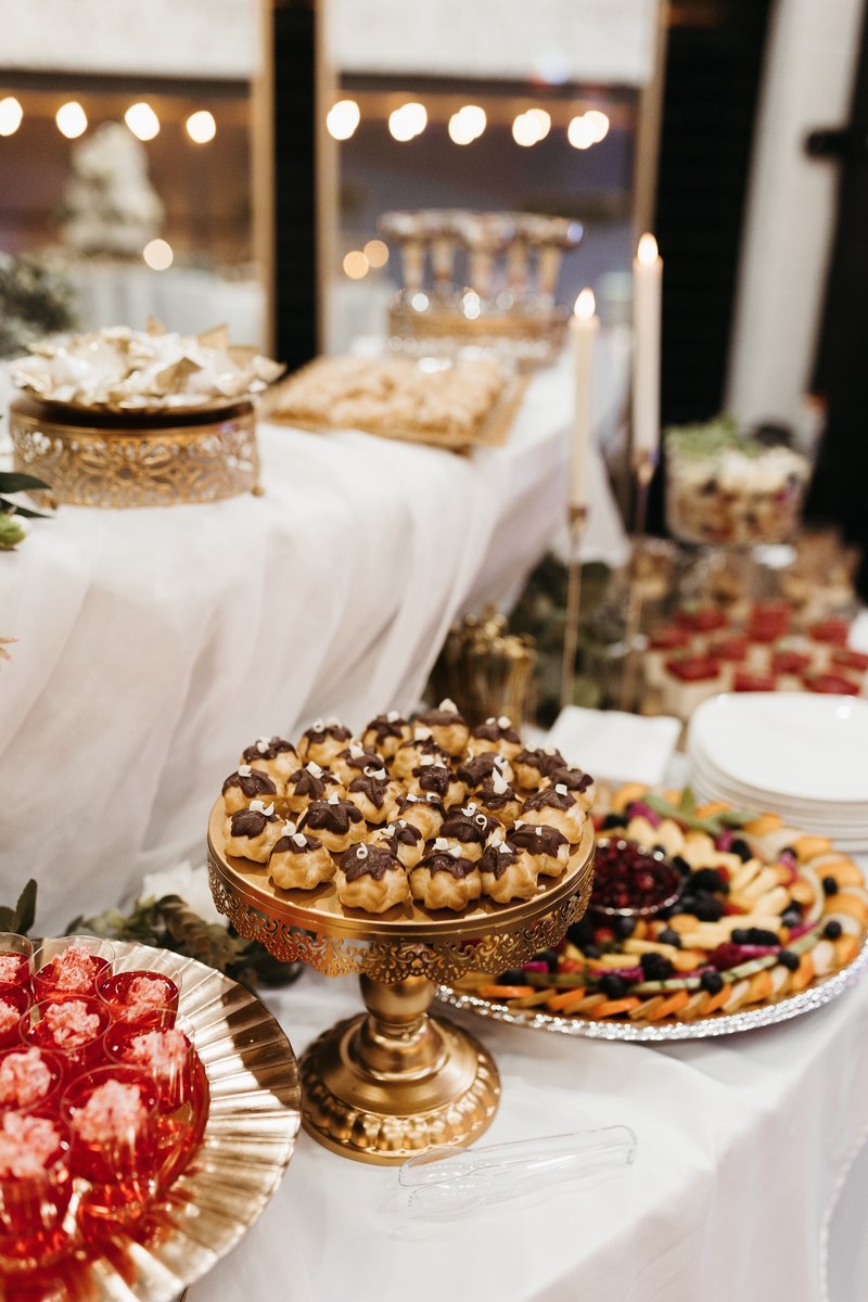 A dessert table with gold cake stands and sweets at our Orem, Utah event venue