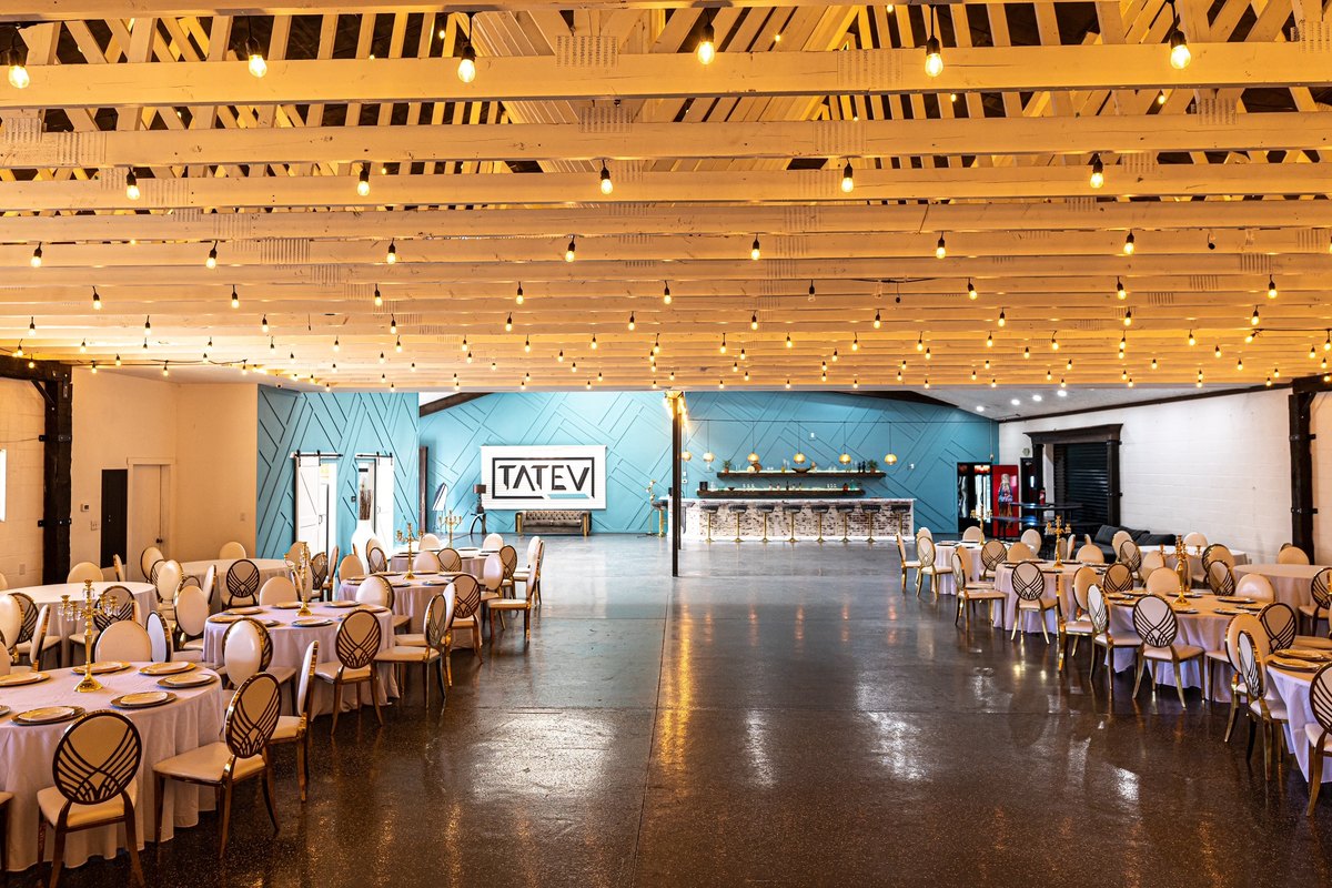 The main hall set with round tables under string lit ceilings at our Orem, Utah event venue