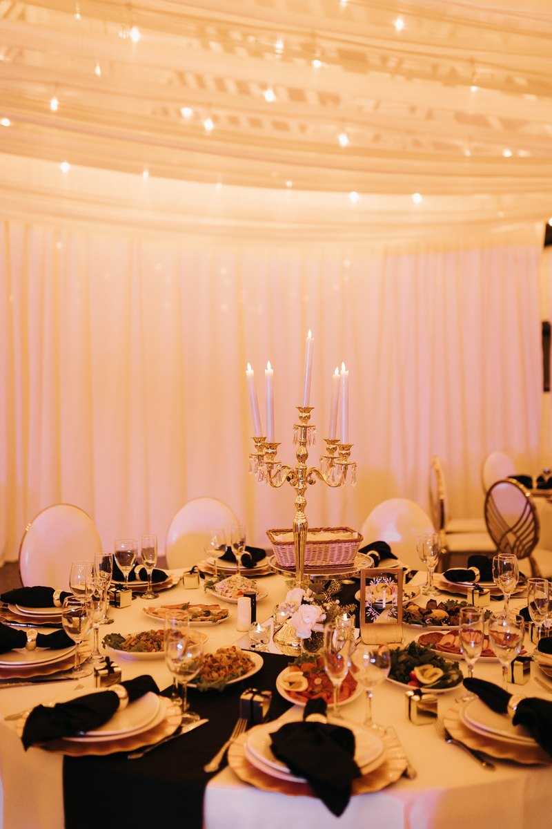 Reception tables set under a draped ceiling and string lights at our Orem, Utah event venue