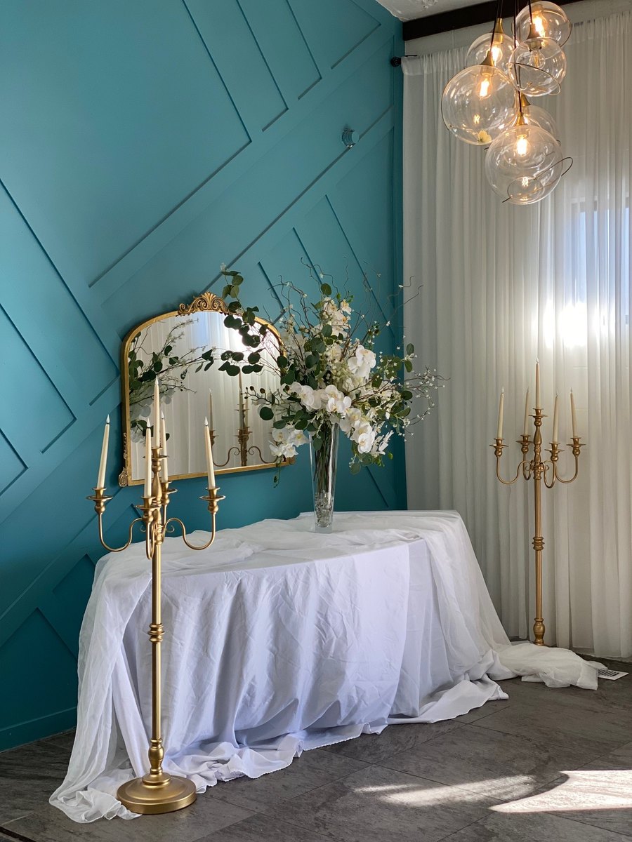 A sweetheart table with florals and a gold mirror at our Orem wedding and quinceañera venue